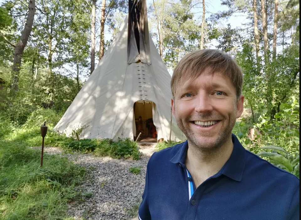Markus vor einem Tipi im Wald.